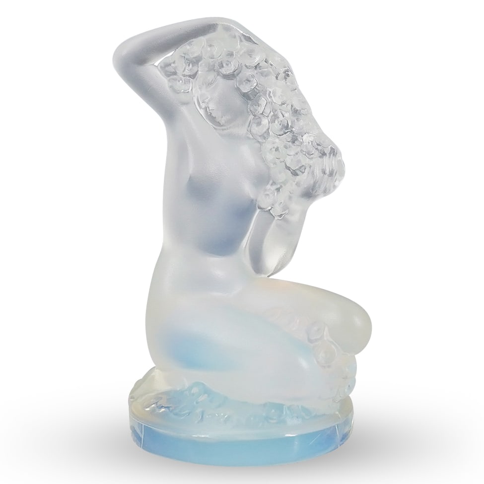 Lalique Art Glass Floreal Nude Figurine: DESCRIPTION: Lalique art glass crystal floreal nude lady figurine features a frosted nude female kneeling with one arm bent over her head clutching cascading hair with flowers adorning the circular ba