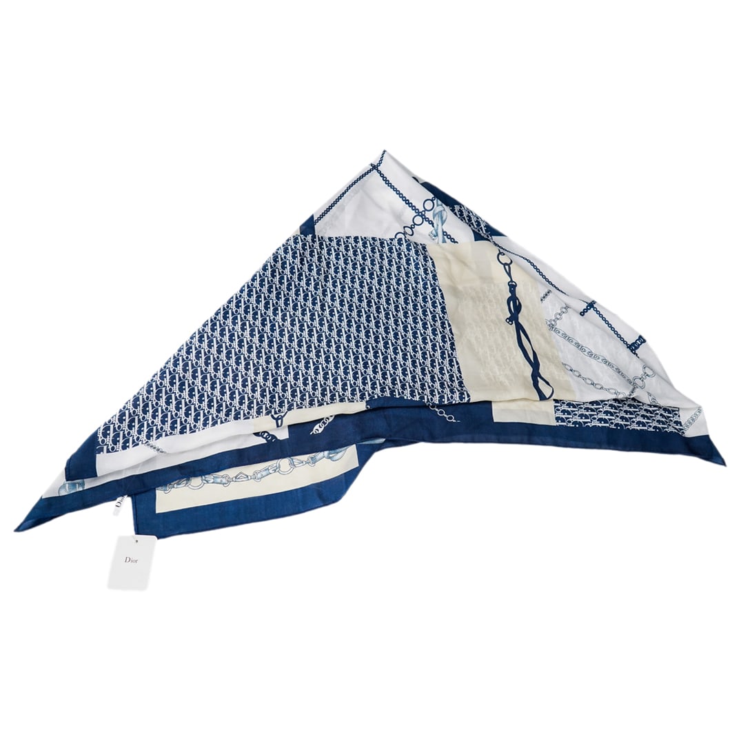 Christian Dior Silk Monogram, Belt, And Chain Pattern Scarf: DESCRIPTION: Silk scarf by Christian Dior featuring monogram, belt, and chain patterns in shades of white and blue. Tag branded "Dior". CIRCA: 20th Century ORIGIN: France DIMENSIONS: W: 34.75" L: 72"