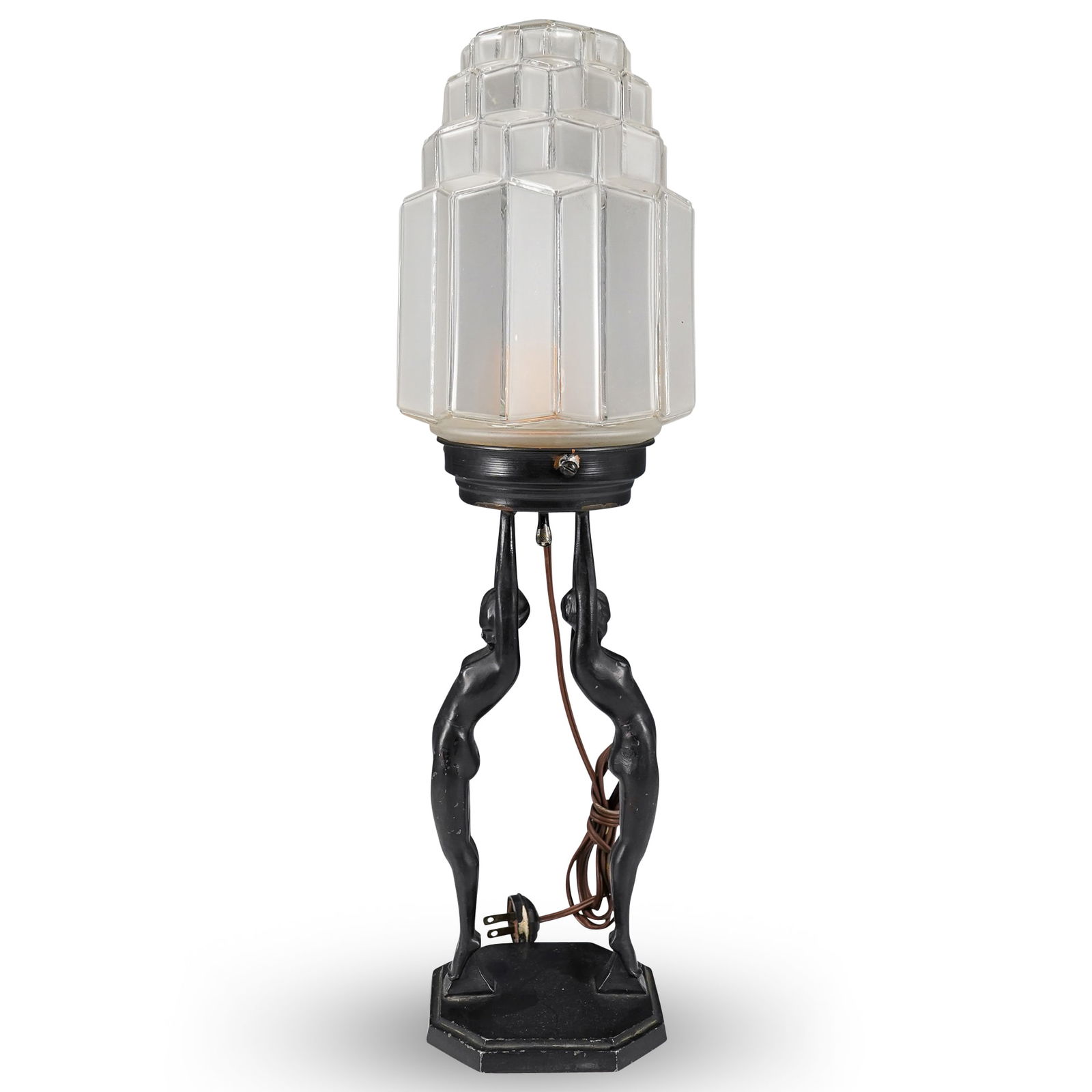 Art Deco Frankart Inc Twin Nude Bronze And Glass Table Lamp: DESCRIPTION: Art Deco table lamp composed of a geometric glass shade mounted on a bronze base depicting two nude women raising the support for the lamp proper. Marked "Frankart '27" on base. CIRCA: 19