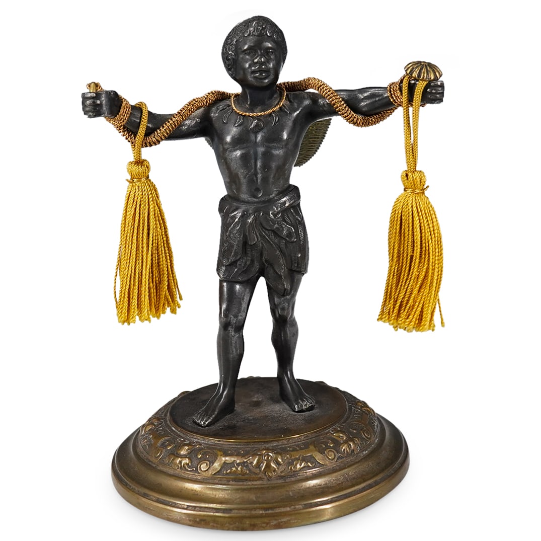 Antique European Mixed Metal Blackamoor W/ Tasseled Basket: DESCRIPTION: Antique mixed metal figurine depicting an African man wearing a fez and bearing a tasseled basket while standing on a flower and foliage ringed platform. CIRCA: Early 20th Century ORIGIN: