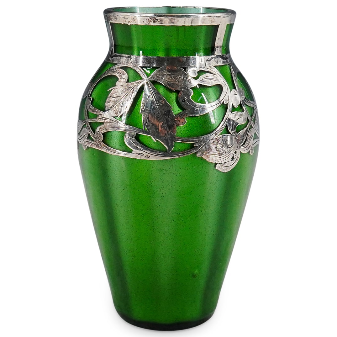 Art Nouveau Loetz Silver Overlay Green Glass Vase: DESCRIPTION: Art Nouveau Loetz vase featuring silver overlay flowers and foliage around its shoulder and silver overlay accenting around neck and lip. CIRCA: 1890s-1910s ORIGIN: Czechoslovakia DIMENSI