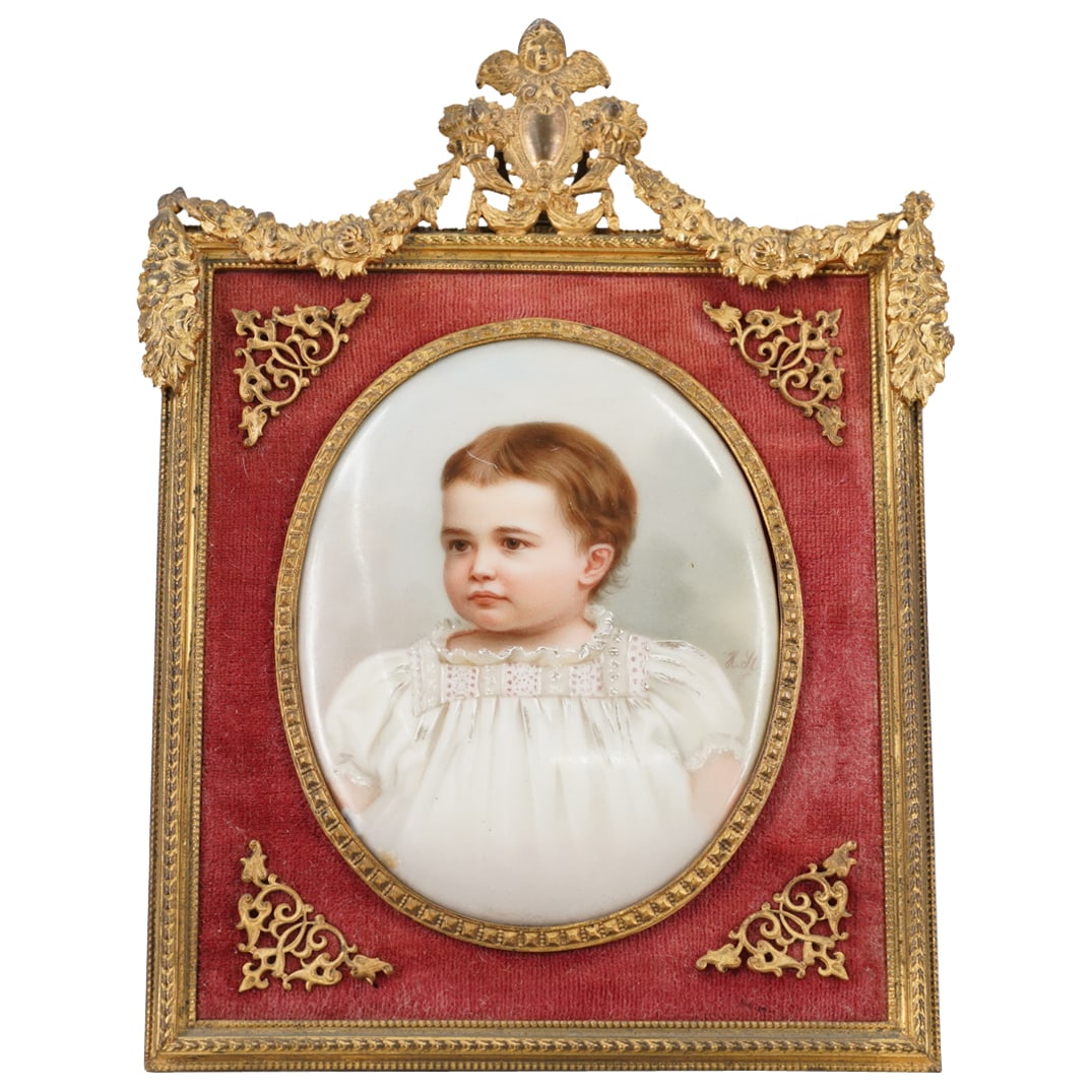 French Empire Hand Painted Porcelain Baby Portrait: DESCRIPTION: French empire hand painted portrait on porcelain, depicting a baby in a white christening gown. Framed in a gilt bronze frame, featuring florals, scrollwork, and a winged angel at the top