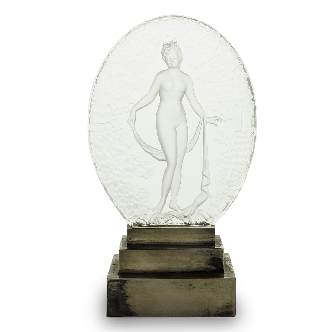 Lalique Style Crystal Intaglio Nude Woman On Metal Base: DESCRIPTION: Intaglio crystal medallion in the style of Lalique depicting a nude woman bearing a scarf and standing among foliage. Mounted on a metal base. CIRCA: 1890s-1940s ORIGIN: France DIMENSIONS