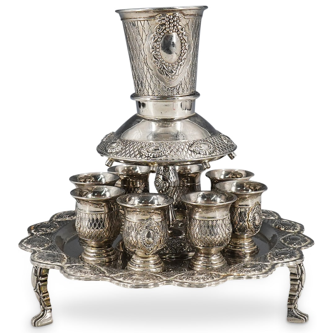 (11 Pc) Silver Plated Judaica Kiddush Wine Fountain: DESCRIPTION: Silver plated Judaica Kiddush three legged wine fountain with 8 cups. Made for Shabbat Kiddush ritual. Diver comes with one large Kiddush goblet featuring grapes filigree designs, and eit