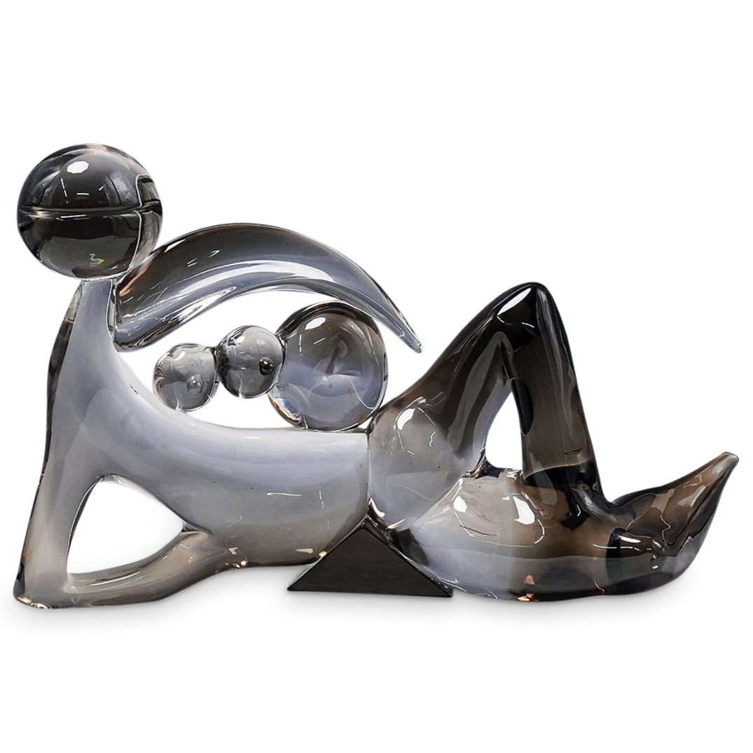 Oscar Zanetti (Italian, born 1961) Murano Glass Reclining Nude: DESCRIPTION: Glass sculpture by Oscar Zanetti depicting a highly stylized nude woman reclining on her right elbow. Signed on base at lower right. CIRCA: 20th Century ORIGIN: Italy DIMENSIONS: H: 13.75