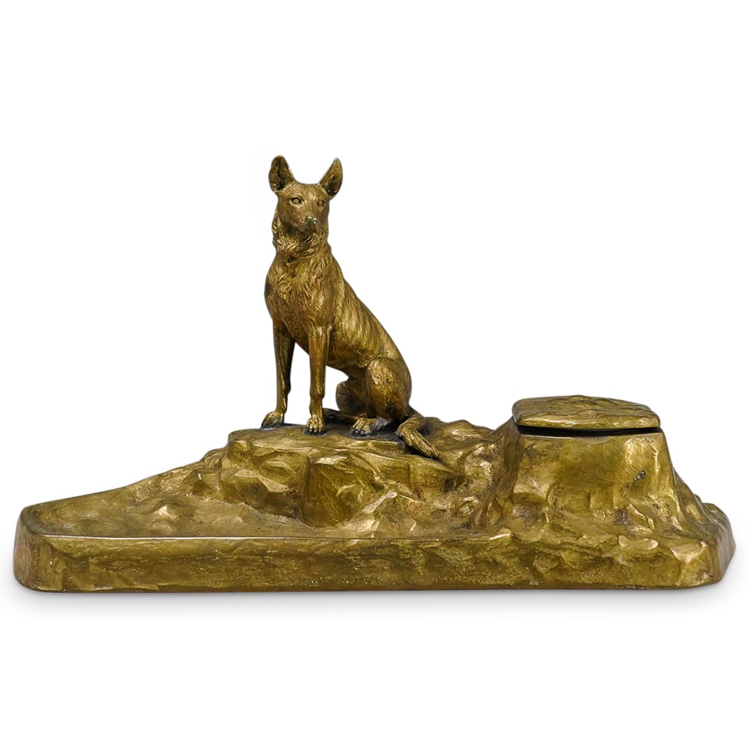 Gilt Bronze Dog Inkwell: DESCRIPTION: Gilt bronze inkwell, featuring seated dog on rock formation base. Lid on right hand side opens to reveal white porcelain jar for ink. CIRCA: 20th Century ORIGIN: France DIMENSIONS: H: 6.2