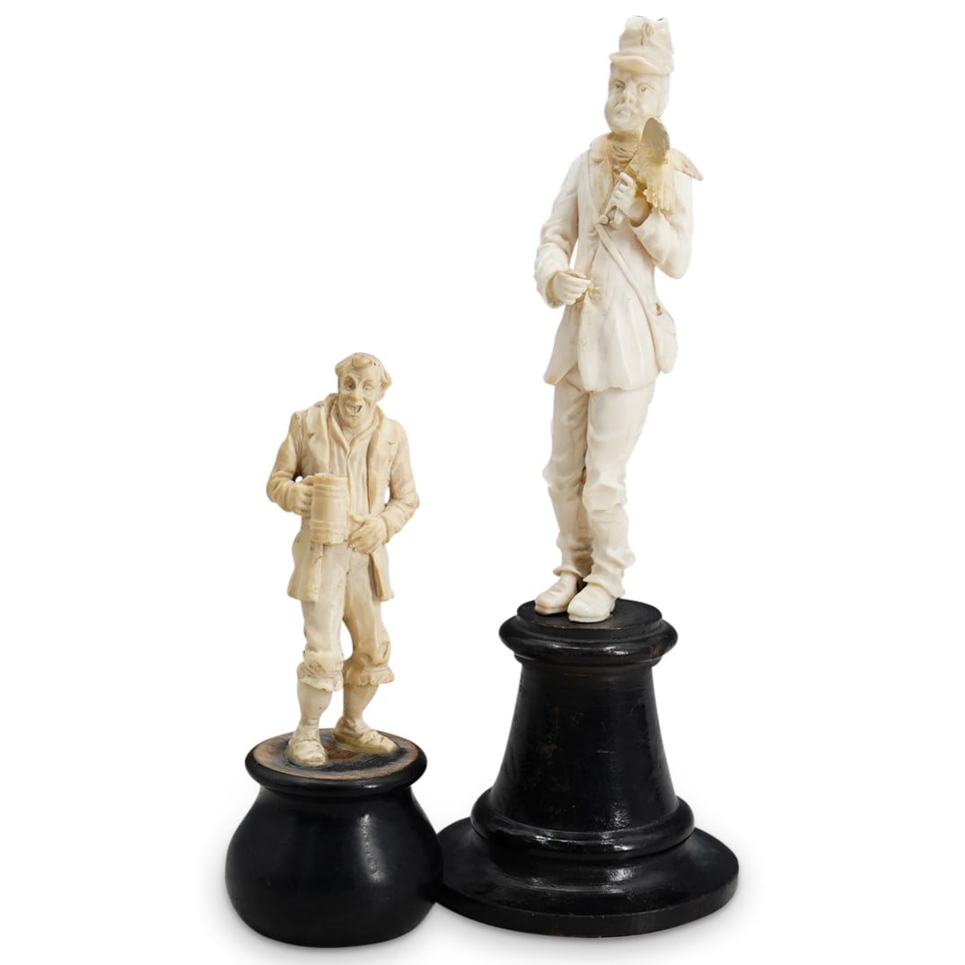(2 Pc) Antique Carved Bone Sculptures: DESCRIPTION: Two carved bone sculptures, one depicting a man in a hat with a satchel bag on, with a bird perched on his left hand. Mounted to dark wood base engraved signature underside. H: 8.75" W: 3