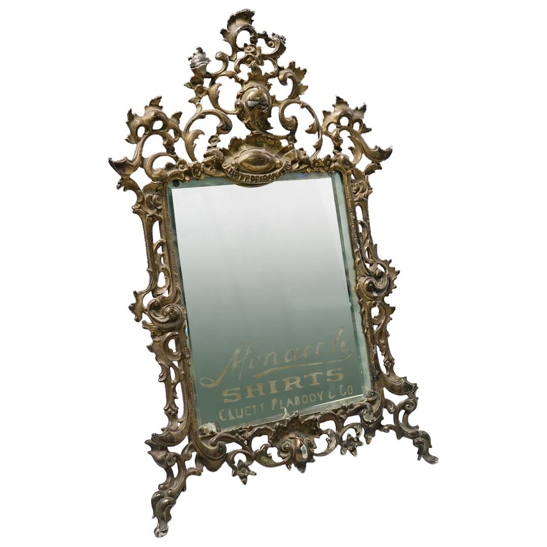 Antique Monarch Shirts Advertising Gilt Bronze Mirror: DESCRIPTION: Antique Monarch Shirts made by Cluett, Peabody & Co. advertising showcase mirror, in gilt bronze with reticulated filigree design throughout. "Monarch Shirts Cluett, Peabody & Co in gilt 