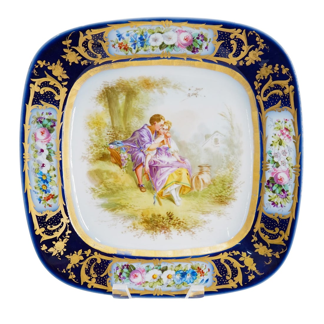 Antique Sevres Lovers Porcelain Centerpiece: DESCRIPTION: Antique Sevres porcelain centerpiece platter. Featuring a finely painted portrait of a loving couple sitting outdoors. Cobalt trim with delicate flowers and gilt accents. Stamped undersid