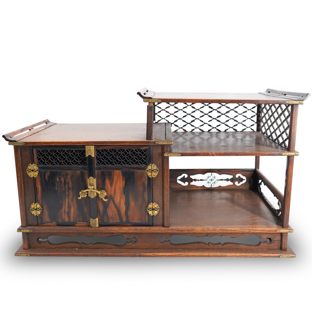 Antique Japanese Carved Wood Three Shelf Tansu: DESCRIPTION: Antique carved wood tansu featuring two shelves on the right and a cabinet on the left concealed by a double door. Shelves sport pierced walls and tansu is finished with brass trimmings a