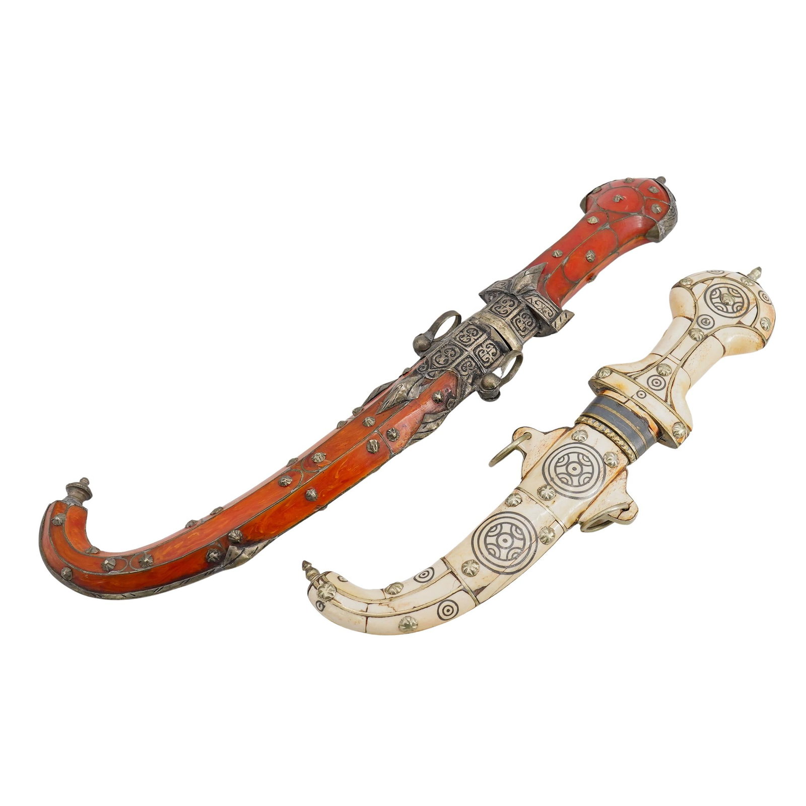 (2 Pc) Antique Oriental Jambiyas In Bone And Resin Sheathes: DESCRIPTION: Two antique jambiya daggers: one longer in a resin sheathe coated in metal studs and trimmings, one shorter in a bone sheathe likewise coated in metal studs and trimmings. CIRCA: Early to