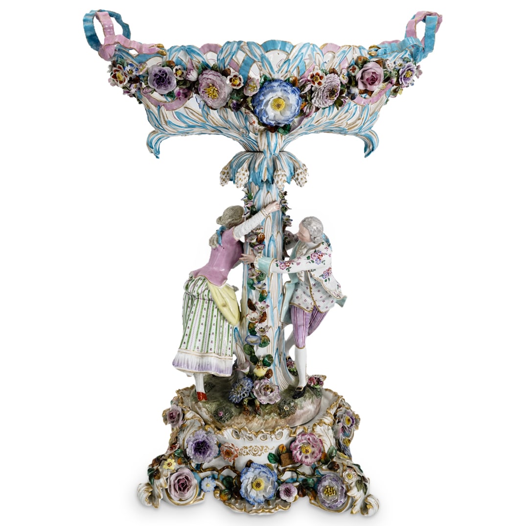 Monumental Antique T Meissen Figural Centerpiece: DESCRIPTION: Antique T Meissen centerpiece crafted as a pierce foliage bowl ringed with flower designs and ribbons, painted with floral motifs, and supported on a foliage form pillar bursting with gil