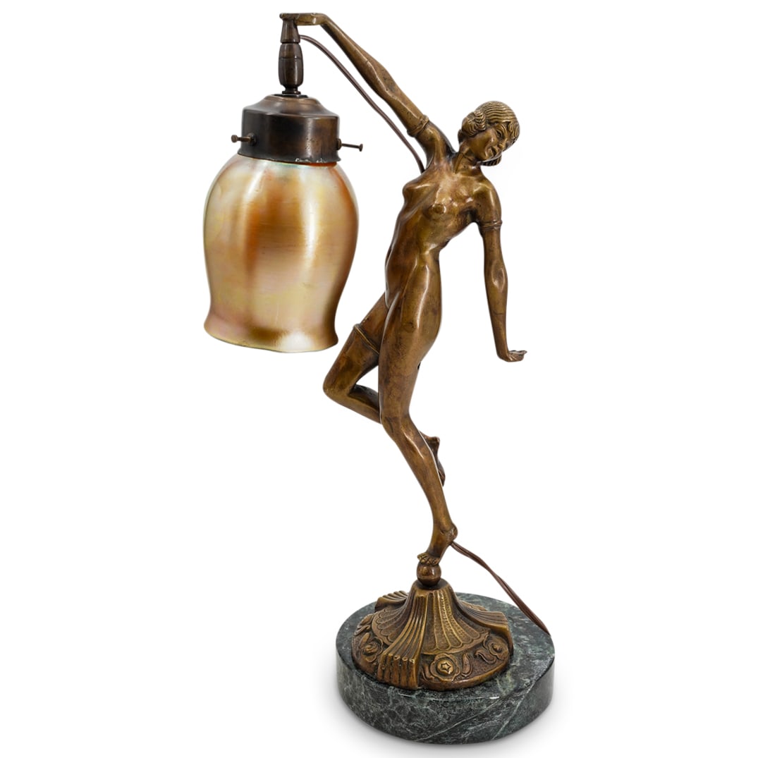 Art Deco Figural Bronze Desk Lamp W/ Iridescent Glass Shade: DESCRIPTION: Art Deco figural bronze desk lamp in the style of Demetre Chiparus depicting a nude female figure holding a tulip shaped lamp shade in iridescent gold glass. The bronze figure rests atop