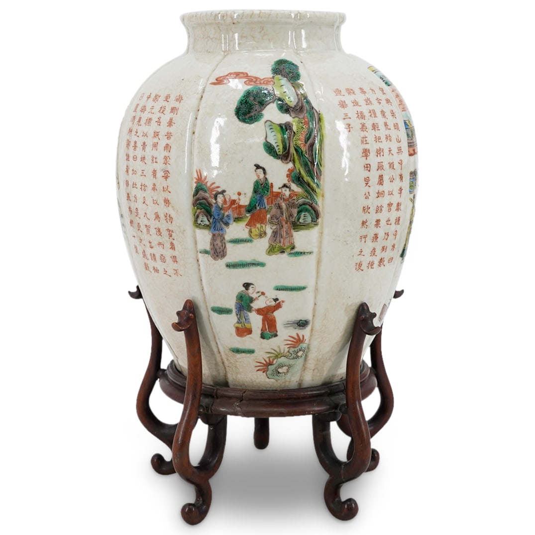 Antique Chinese Famille Verte Porcelain Vase On Carved Wood Stand: DESCRIPTION: Antique famille verte porcelain vase featuring a gadrooned exterior with eight facets depicting alternating court and garden scenes punctuated by descriptions inscribed in Han characters.