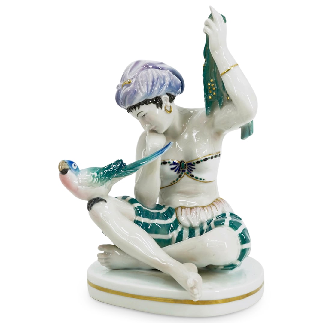 German Gypsy Girl Porcelain Figurine: DESCRIPTION: Porcelain figurine, depicting a gypsy girl wearing a turban sitting with her legs crossed, golding an emerald tone handkerchief in one hand. A multi colored parrot sitting on her right le