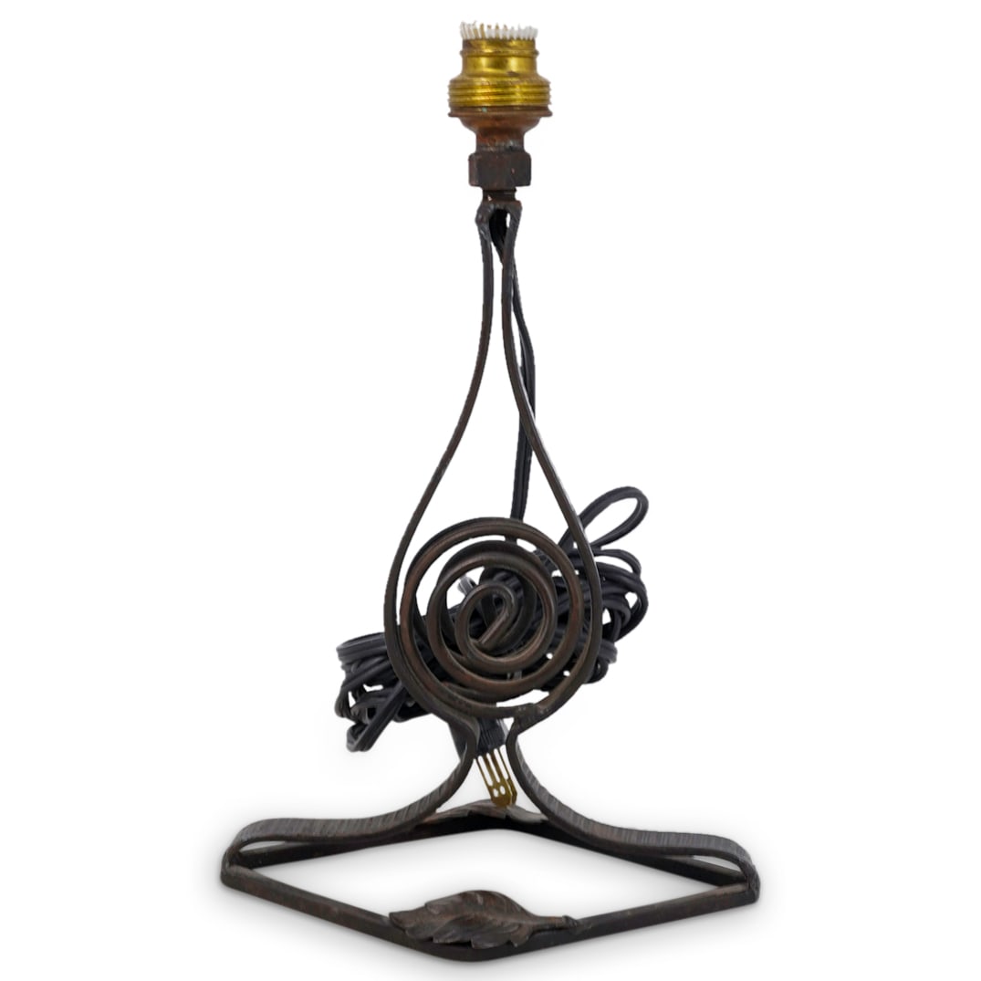 Art Deco Wrought Iron Lamp Base: DESCRIPTION: Art Deco wrought iron boudoir or desk lamp base in the manner of Edgar Brandt, the stem centered by a coil, the diamond-shaped foot decorated with two applied leaves. CIRCA: Early - mid 2