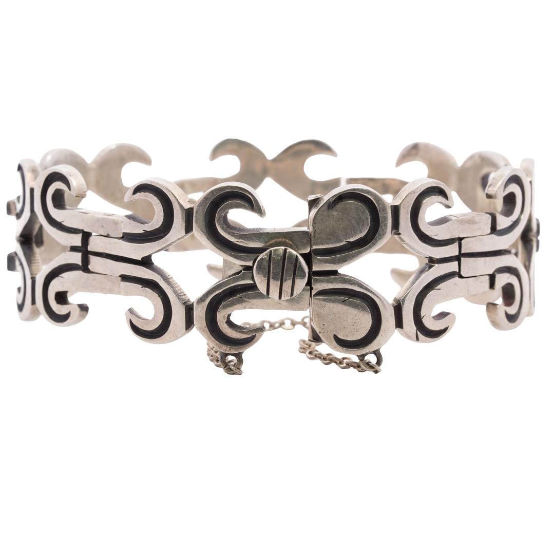 Vintage Taxco Sterling Silver Bracelet: DESCRIPTION: Taxco sterling silver bracelet composed of links crafted in connected goat horn shapes. Clasp ends are bound by a delicate chain and one clasp end is hallmarked "Taxco Mexico 925" and "SB