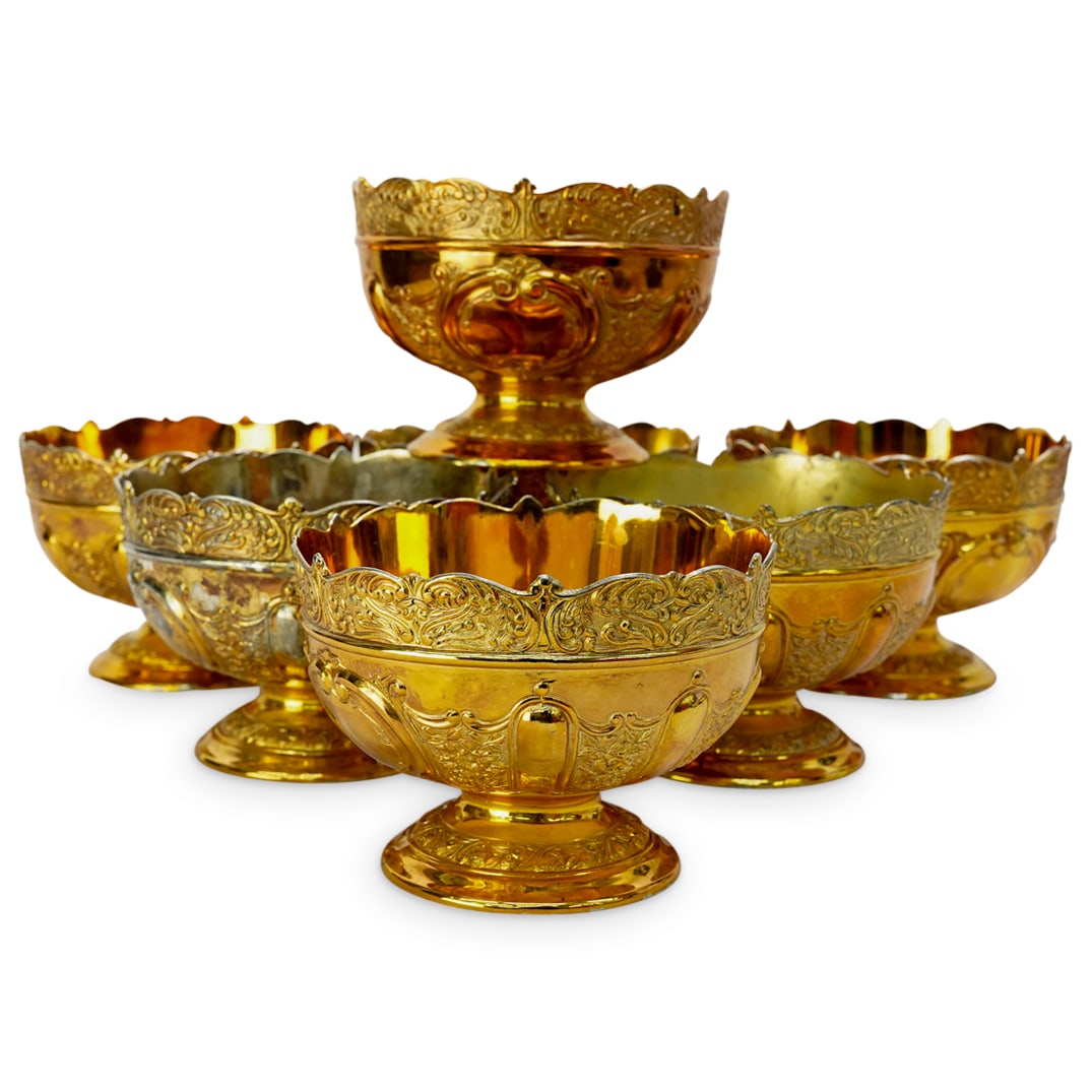 (7 Pc) Gold Washed Gilt Finish Monteith Bowls: DESCRIPTION: Set of 7 gold washed, gilded finish, heavy plated footed Monteith bowls. Featuring ornate scrollwork in repousse throughout. CIRCA: Early 20th Century ORIGIN: Continental DIMENSIONS: H: 3