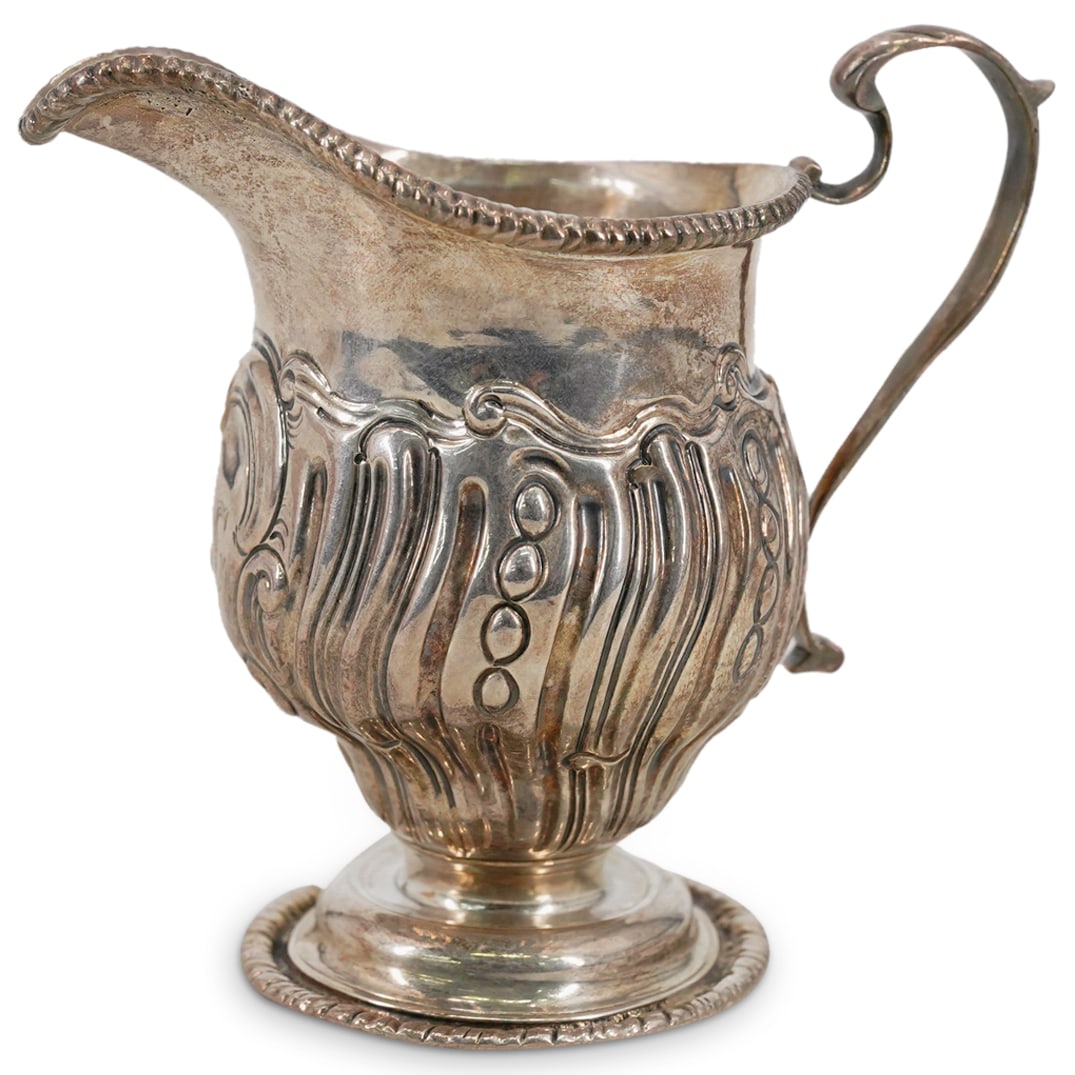Antique English Chester Sterling Silver Creamer: DESCRIPTION: Antique English sterling silver creamer, mark of George Nathan & Ridley Hayes, Chester, date mark illegible, featuring with chased rococo-style decoration and an engraved initial. Marked 