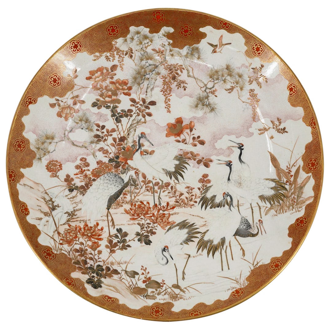 Antique Japanese Kutani Porcelain Charger: DESCRIPTION: Antique Kutani porcelain charger featuring a gilt accented scene depicting cranes among flowers and foliage. Inscription on underside in kanji mentions the Kaga province, suggesting an ea