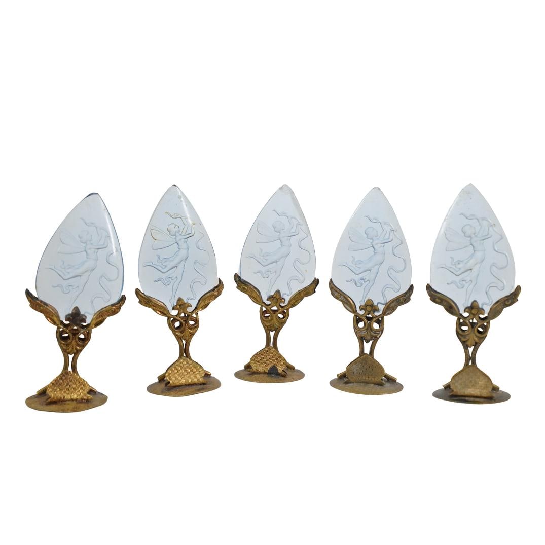 (5 Pc) Glass Intaglio Place Card Holders: DESCRIPTION: Set of 5 gilt place card holders, with blue glass inserts that feature an intaglio cut neoclassical fairy design. Stamped underside "Made in Czechoslovakia" CIRCA: 1900's ORIGIN: Czech DI