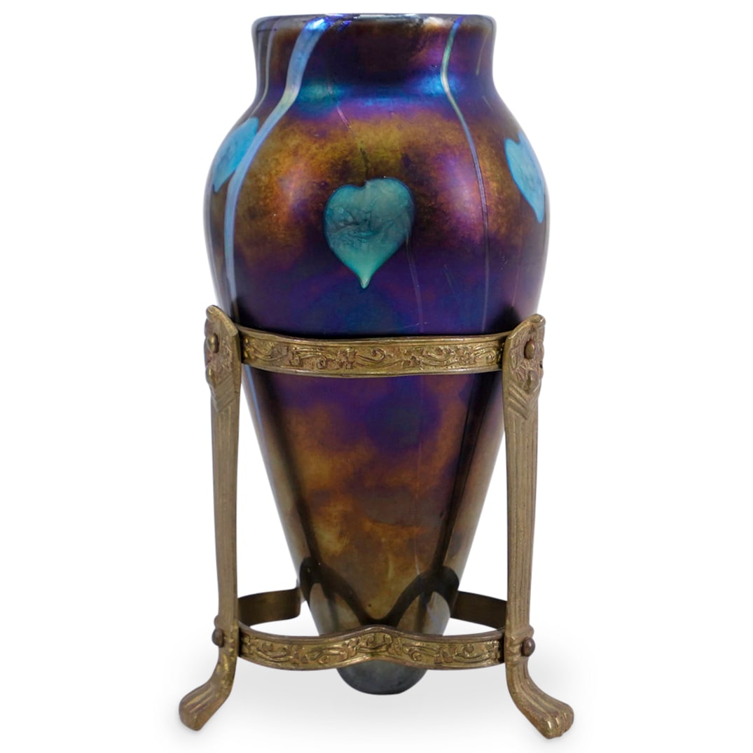 Duran Art Glass Amphora Vase: DESCRIPTION: Duran art glass amphora vase, on gilt bronze metal stand. The art glass vase in iridescent purple and gold tones, with blue heart motifs. Unmarked CIRCA: 20th Century ORIGIN: USA DIMENSIO