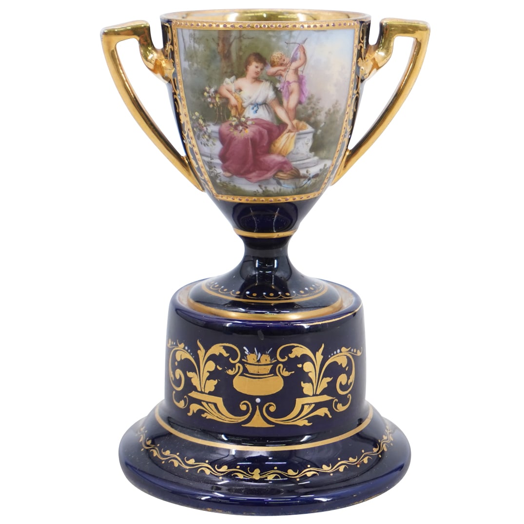 Royal Vienna Miniature Porcelain Urn Vase On Plinth: DESCRIPTION: Royal Vienna miniature porcelain urn vase on plinth, in cobalt blue with gilt decorative motifs, and a central painted scene depicting Venus and Cupid in a garden setting. Marked with bee