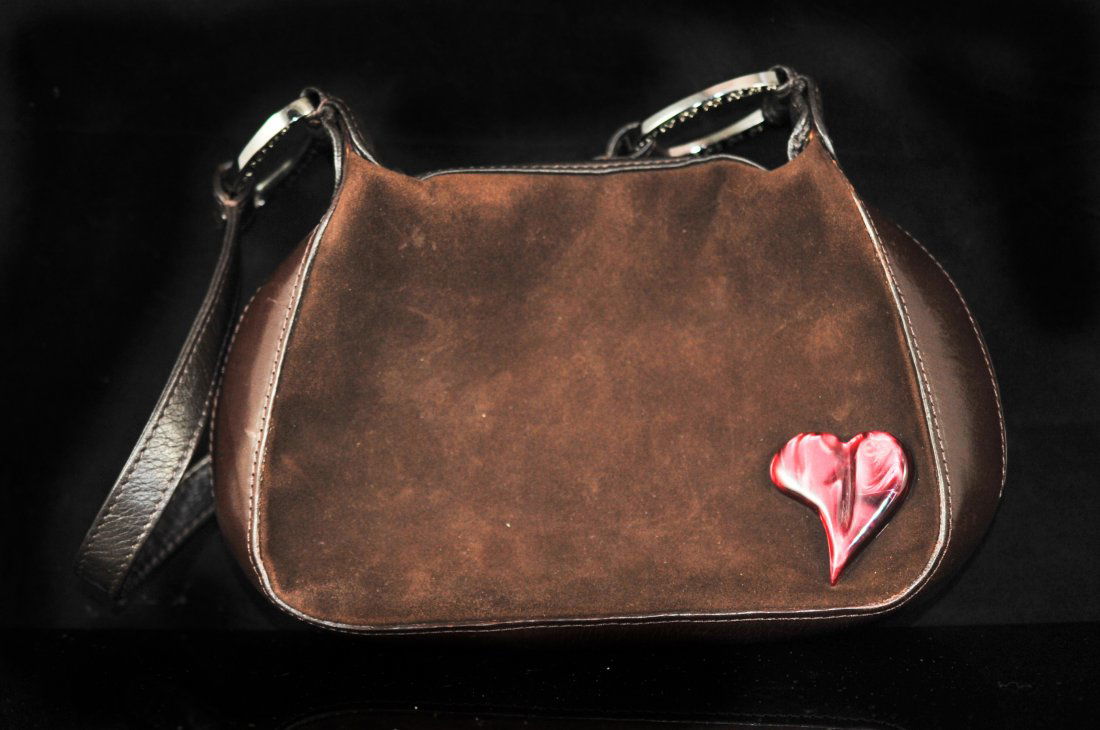 Authentic brown leather and suede Escada handbag: DESCRIPTION: Authentic brown leather and suede Escada handbag. Made from brown suede and leather with a marbled crimson celluloid heart on the lower right corner. The hardware features two metal rings