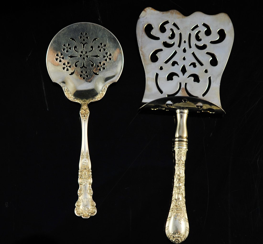 Set of two large sterling serving pieces.: DESCRIPTION: Set of two large sterling serving pieces. First piece is an English sterling server. Second piece is a Gorham sterling server. Both with ornate floral handles. 192 grams CIRCA: Mid 1900's