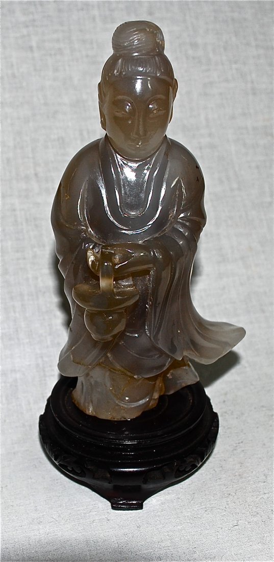 Chinese hand carved agate woman with basket: DESCRIPTION: Chinese hand carved agate woman with basket. Beautiful grayish white agate carved into a woman figure wearing a robe and holding a basket. Minor repair on the lower back. Sits a top a woo