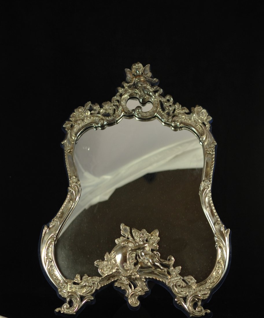 Large sterling Art Nouveau style mirror. Hallmarke: DESCRIPTION: Large sterling Art Nouveau style mirror. Oversized Nouveau style mirror with an ornate sterling frame. Features two fairies: One at the center top and the center bottom. One holds a handh