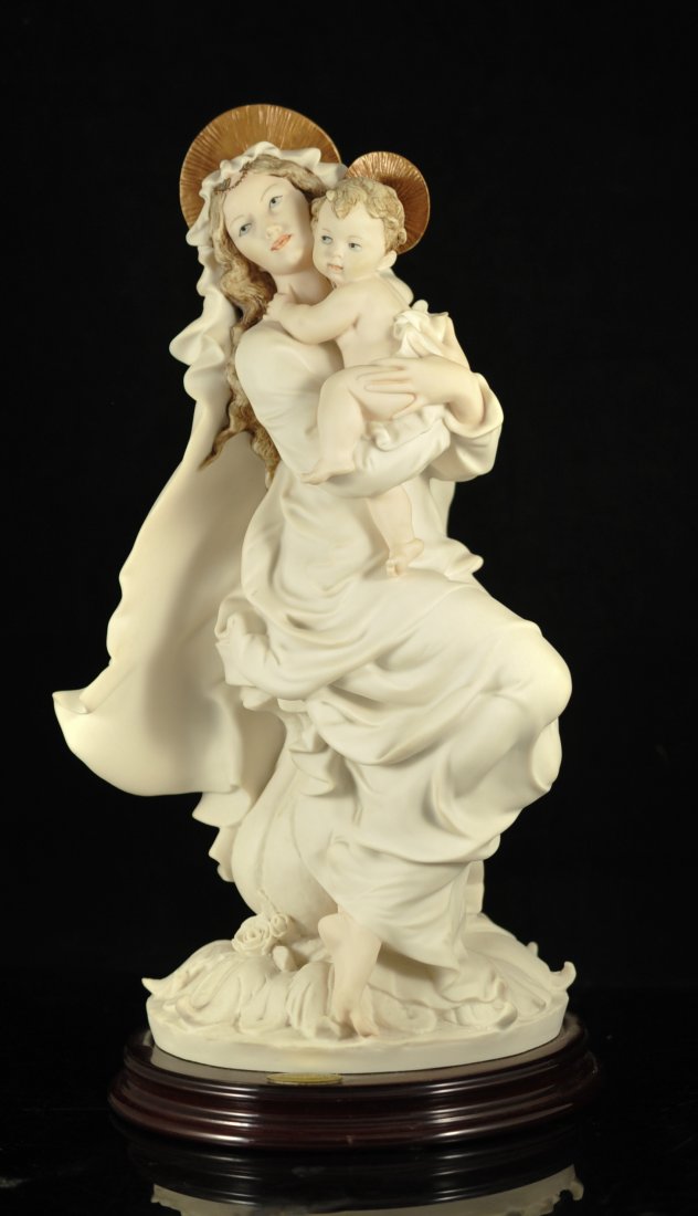 Giuseppe Armani Bisque porcelain figure: DESCRIPTION: Giuseppe Armani Bisque porcelain figure. White porcelain figure of a a woman nestling a baby. she wears a long flowing robe and swaddles the child in a cloth. She sits a top a floral pede