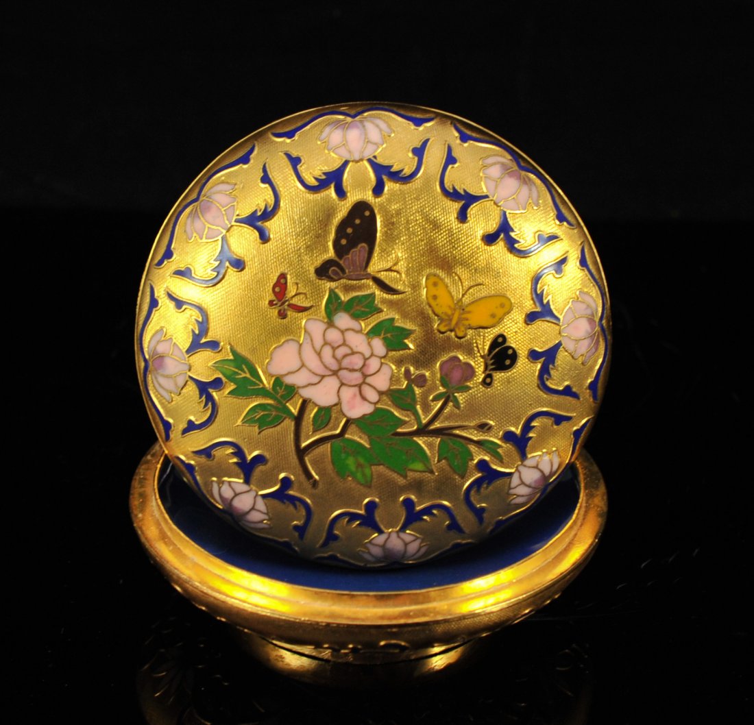 French dore bronze and champleve enamel box: DESCRIPTION: French dore bronze and champleve enamel box. Short squat bronze body design with an exterior gold gilt. The lid and body features a multi colored champleve enamel scene of butterflies flu