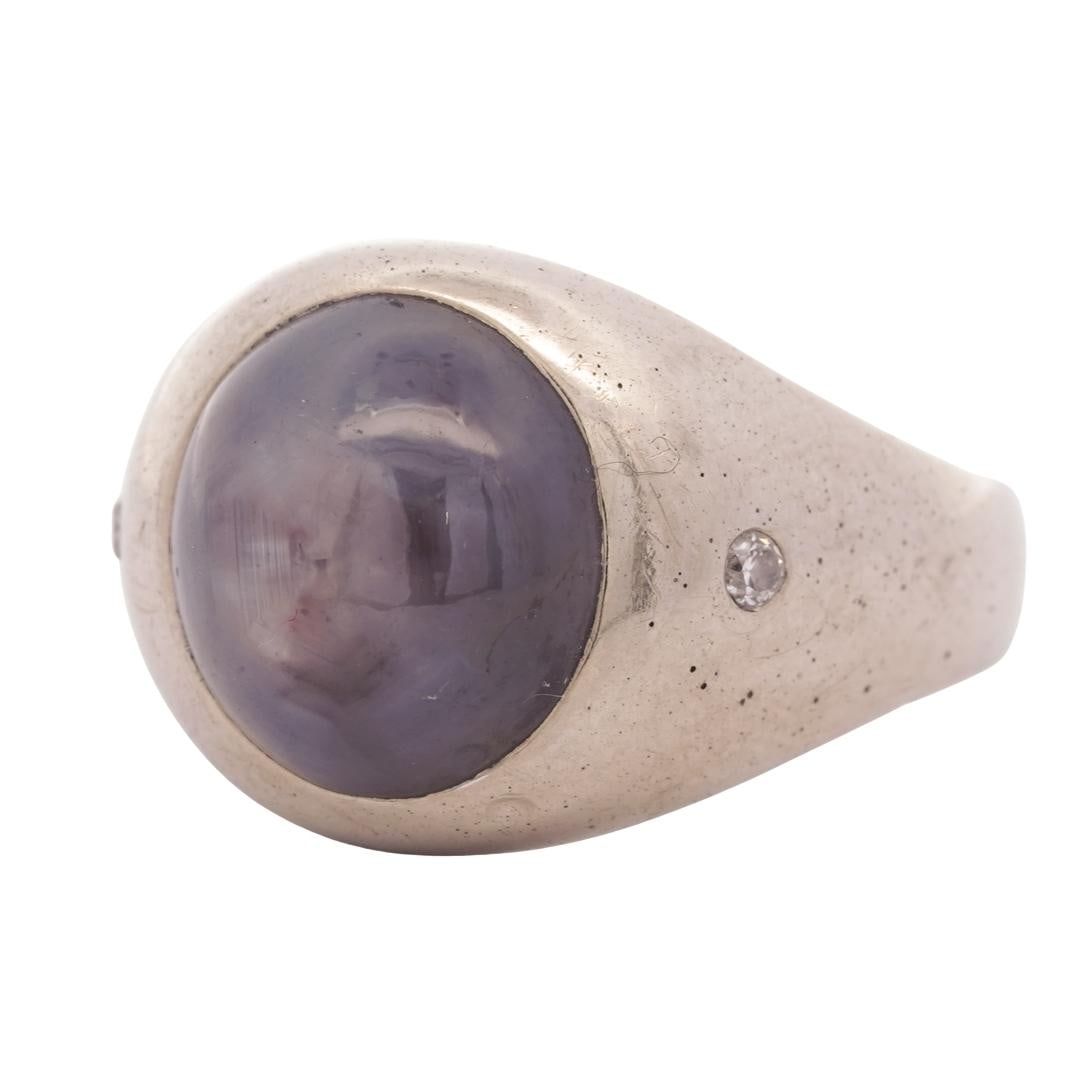 14k White Gold, Star Sapphire, and Diamond Ring: DESCRIPTION: 14k white gold ring, featuring a star sapphire cabochon in the center, small round cut diamond accents on either side of sapphire adding a touch of sparkle. Total weight: 7.95g (5.11 dwt)