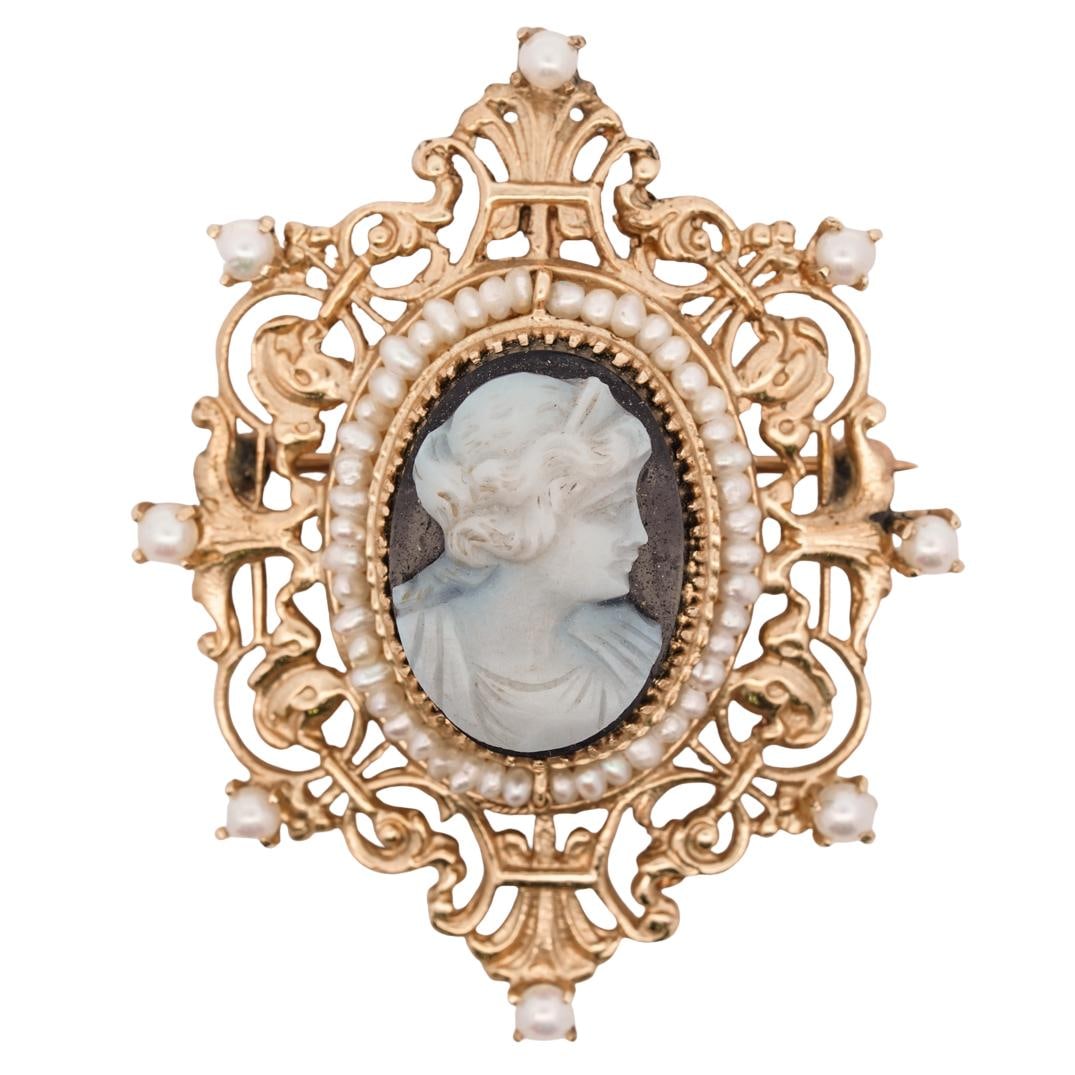 14k Gold, Carved Shell, and Seed Pearl Cameo Brooch: DESCRIPTION: 14k gold brooch, features a classic carved cameo at its center, depicting a beautifully detailed profile a woman in relief. Surrounding the cameo is a delicate border of seed pearls. The 