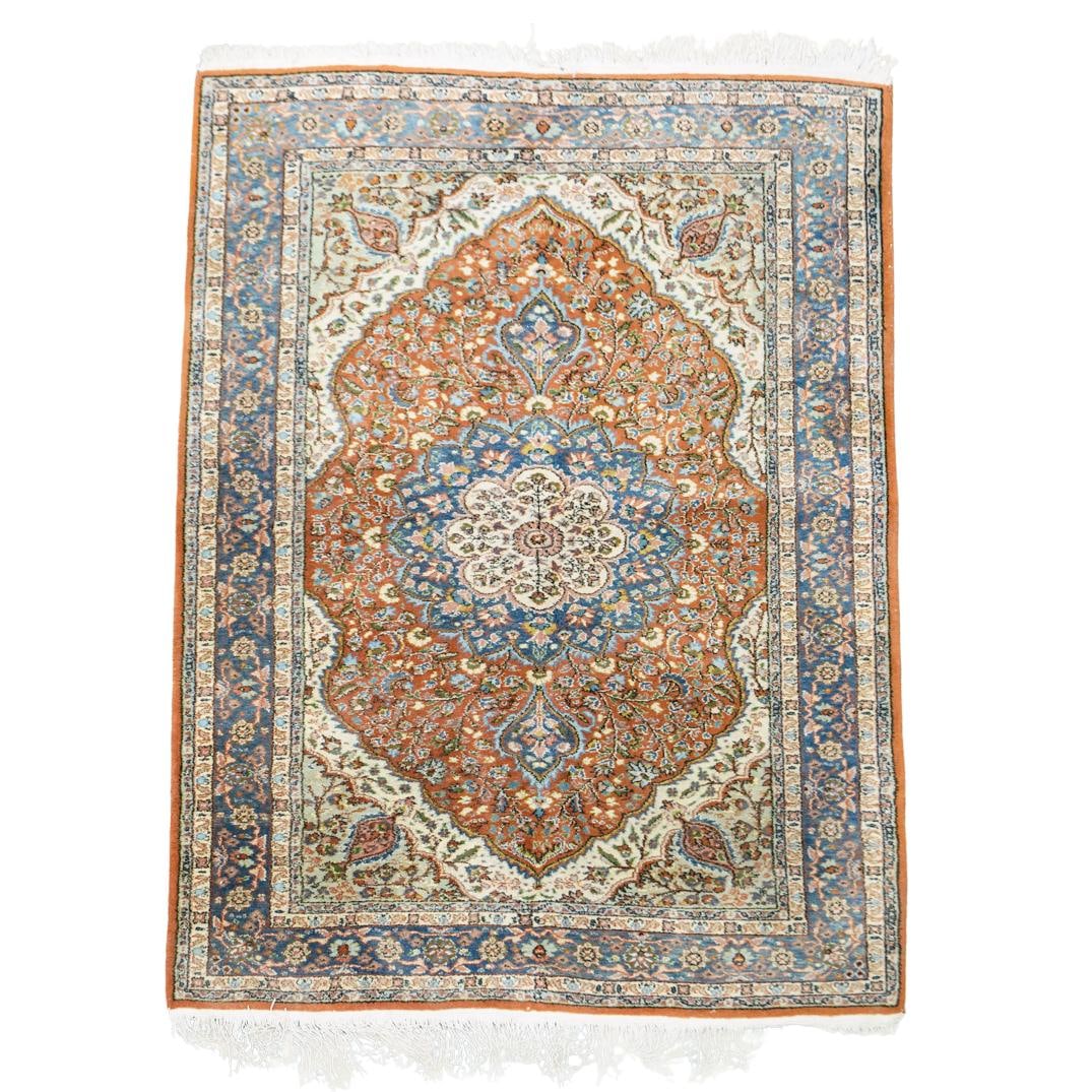 Persian Wool Pile Rug: DESCRIPTION: Persian wool pile rug, featuring prominent central medallion surrounded by floral motifs. The background around the medallion is filled with densely packed floral motifs and multiple bord