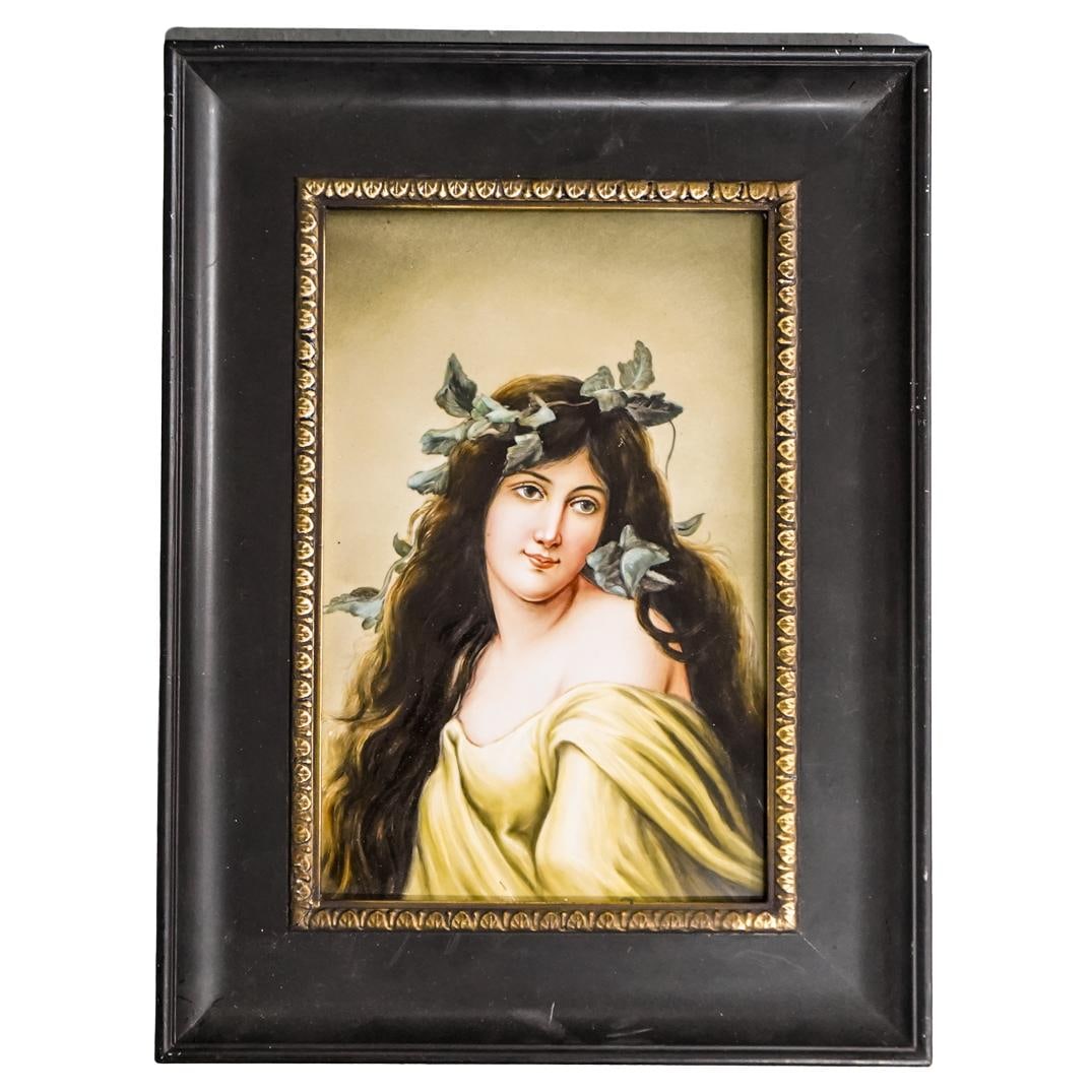 KPM Hand Painted Porcelain Plaque: DESCRIPTION: A beautifully hand painted porcelain plaque by KPM, depicting a young woman adorned with leaves in her hair. The plaque is set in an ornate frame, highlighting its elegance and classic ap