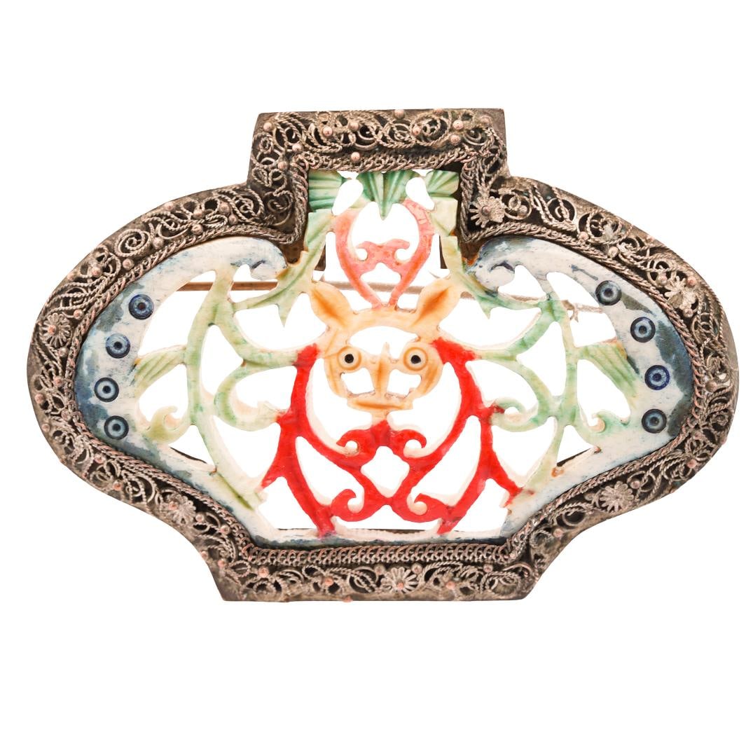 Chinese Carved Bone & Mixed Metal Bat Pin: DESCRIPTION: Chinese carved bone and mixed metal pin, the centerpiece is a carved bone design depicting a bat with hand painted accents in red, green, yellow, pink, and blue. The surrounding frame is 