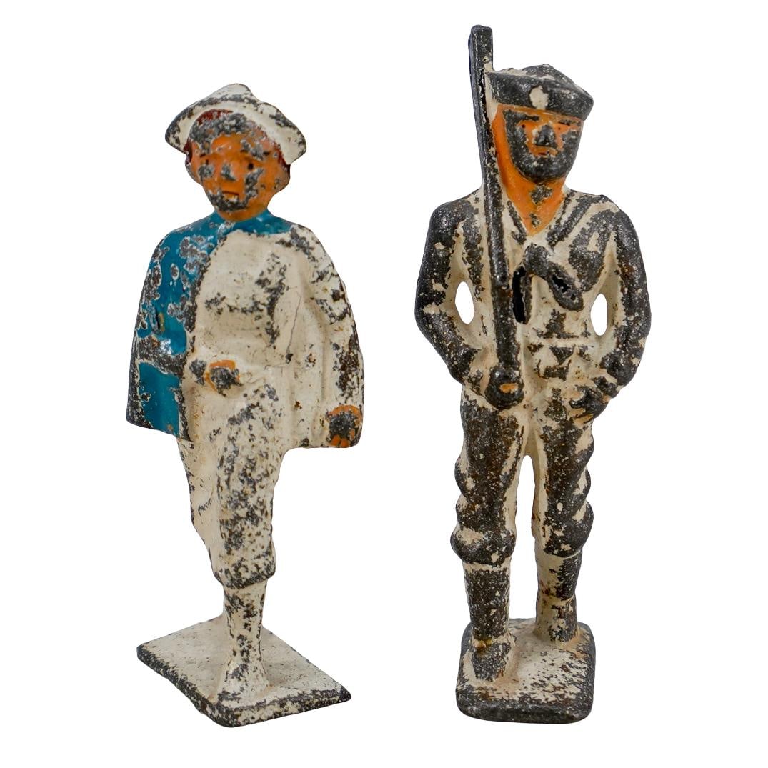 (2 Pc) Military US Miniature Navy Soldier & Nurse Figurines: DESCRIPTION: (2 Pc) Pair of miniature military cast metal lead figurines, with white patina finish, including one (1) navy soldier figurine and one (1) nurse figurine. Includes a total of two (2) figu