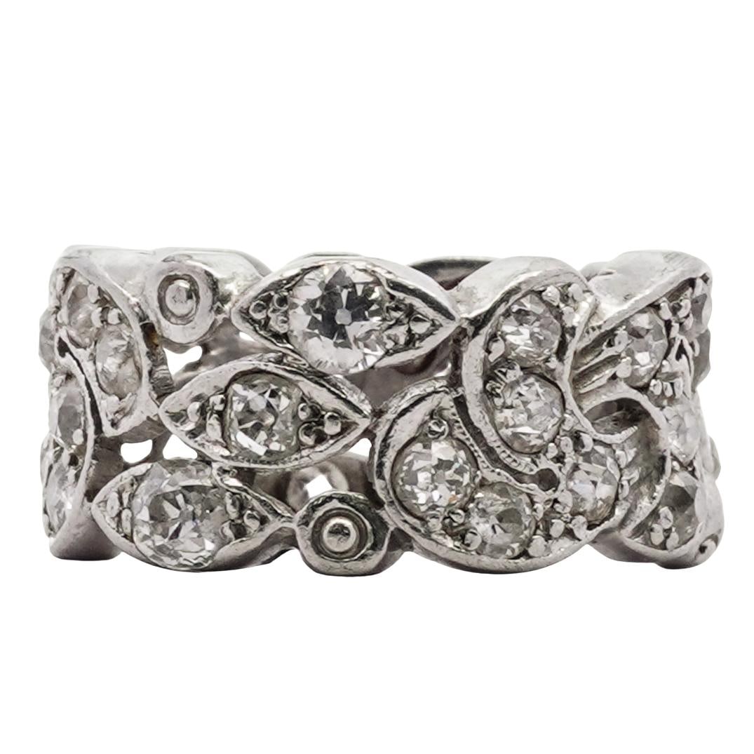 18k White Gold and Diamond Ring: DESCRIPTION: 18k white gold and diamond ring, featuring intricate patterns resembling intertwining vine motifs. The ring is extensively set with brilliant cut diamonds in pave style (approx. 1.5 carat