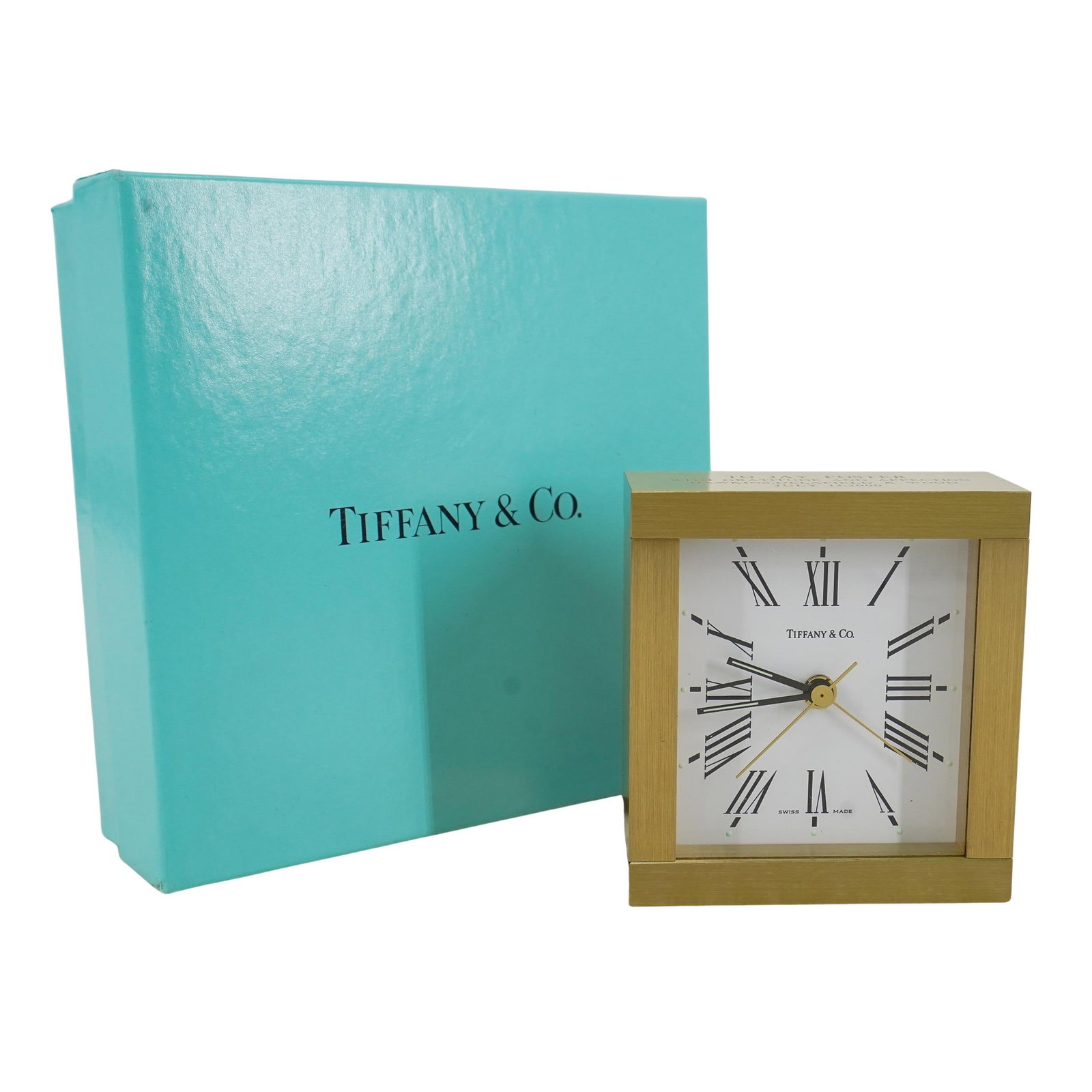 Tiffany & Co. Square Desk Clock: DESCRIPTION: Tiffany & Co desk clock crafted from gilt bronze and featuring a dedication etched in side reading "To Jay Foster with gratitude and affection Hawkins, Delafield & Wood July 13, 2000". In