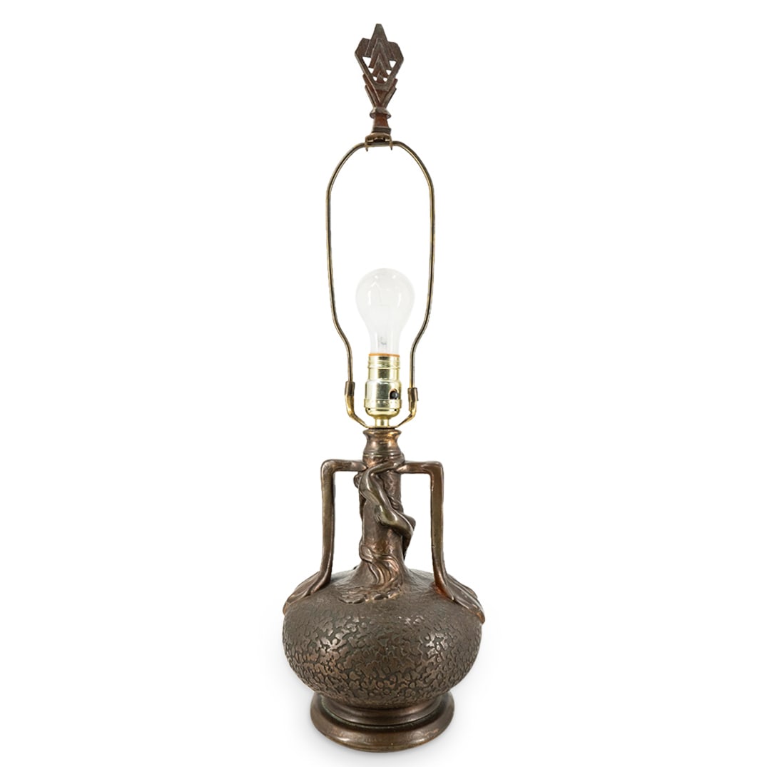 Olive Kooken (American, 1904 - 1964) Art Nouveau Bonded Bronze Lamp: DESCRIPTION: Art Nouveau bonded bronze electric lamp featuring a nude woman embracing the narrow neck of the bulging, bulbous base. Tested and fully functional. CIRCA: Early 20th Century ORIGIN: Conti