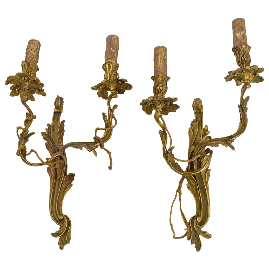 Pair Louis XV Style Gilt Bronze Sconces: DESCRIPTION: Pair of antique Louis XV style gilt bronze sconces, featuring a sinuous, asymmetrical shape with decorative acanthus leaves and floral accents extending along the arms and base. Each scon