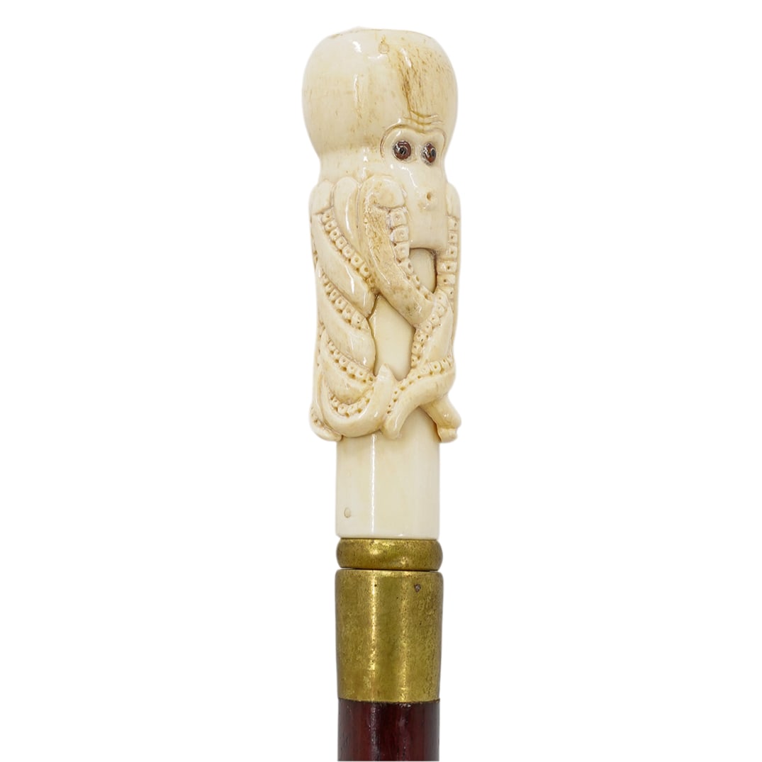 Vintage Carved Bone Nautical Cane: DESCRIPTION: A vintage cane comprised of a wooden foundation, fitted with a carved bone handle depicting an octopus with glass inserted eyes. CIRCA: Mid-Late 20th Cent. ORIGIN: USA DIMENSIONS: H: 36" 