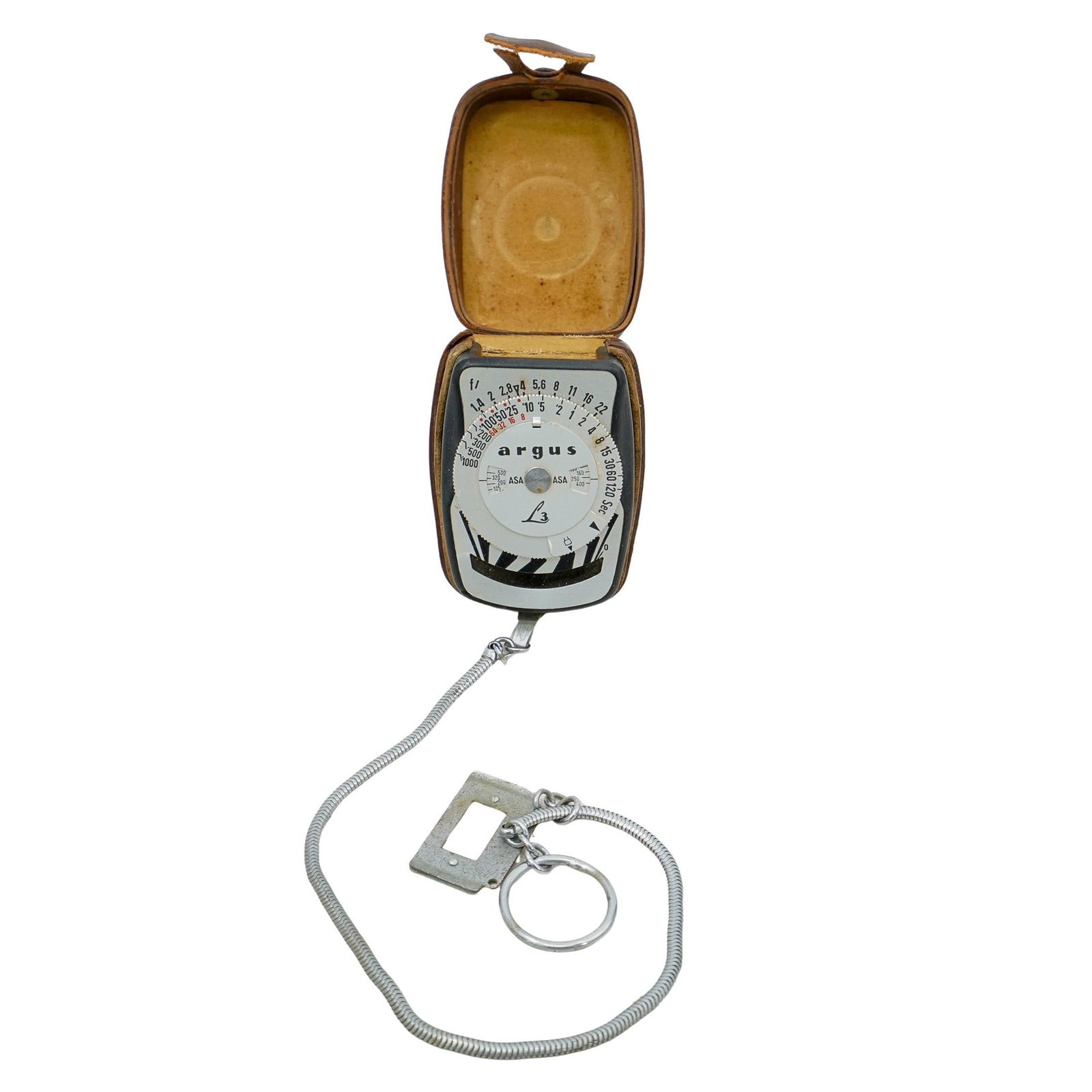 Argus L3 Photography Light Meter: DESCRIPTION: Vintage Argus model L3 light meter, used in photography to measure light levels for proper exposure settings. Comes with a leather case and a chain for portability. Measures approx. H: 1.