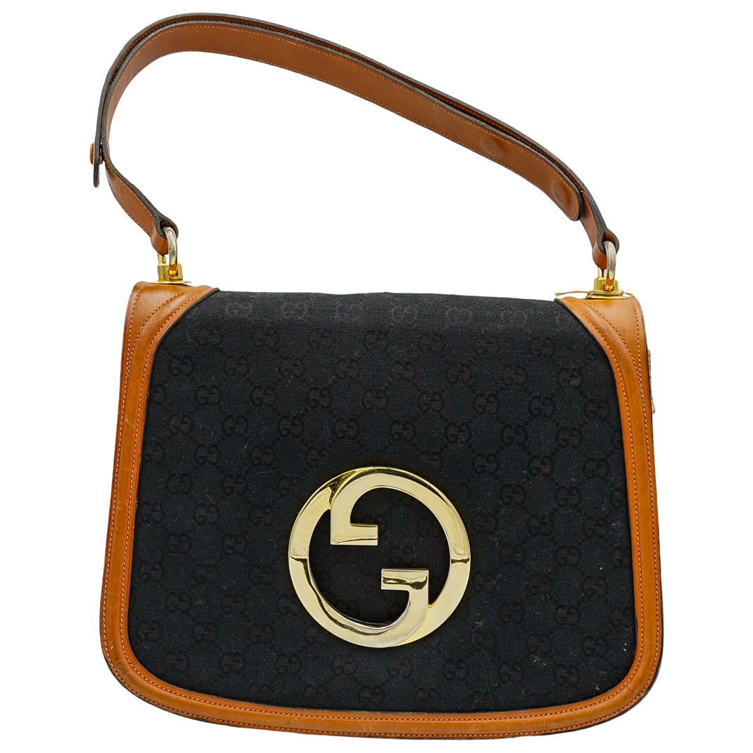 Vintage Gucci Blondie Bag: DESCRIPTION: This Gucci Vintage blondie bag is in the classic GG black monogram canvas with brown leather trim. Has large interlocking GG logo in gold tone hardware on front. Snap button closure on fr