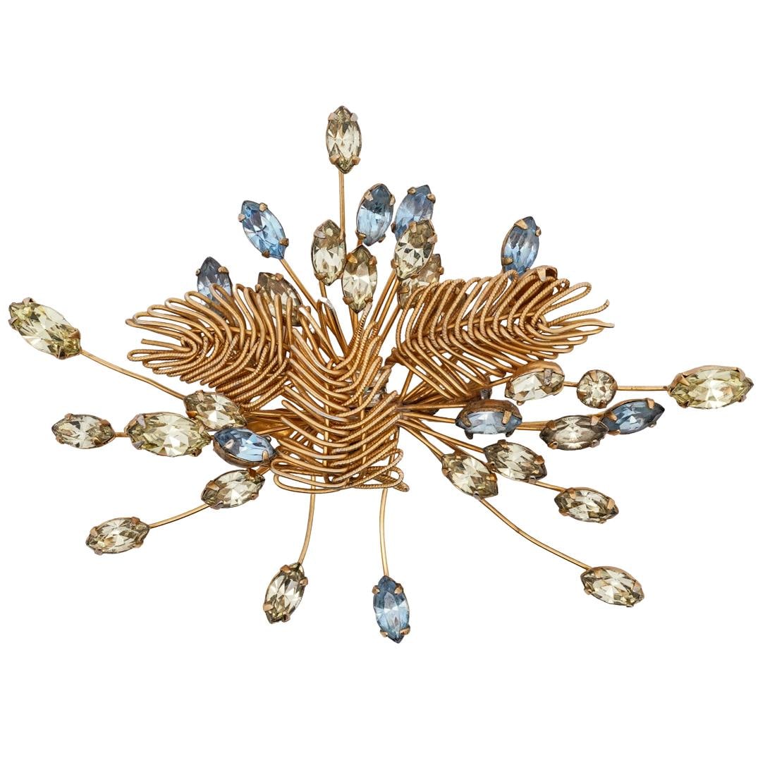 Hattie Carnegie Gold Toned Brooch: DESCRIPTION: Hattie Carnegie gilded brooch, the structure is crafted with signature wirework, with delicate stems extending outward. Each stem is tipped with vibrant oval cut gemstones in shades of pa