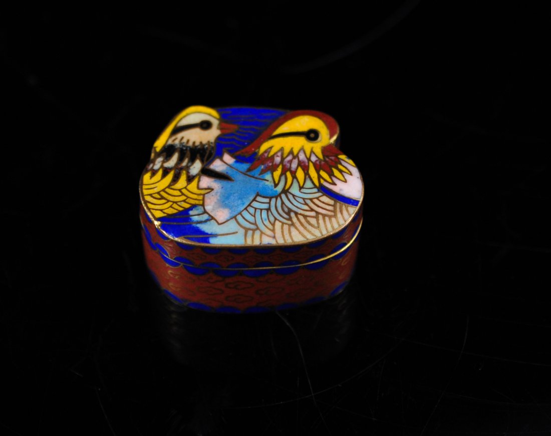 Antique Chinese bird cloisonne pill box: DESCRIPTION: Antique Chinese bird cloisonne pill box. Unique shape with twin birds done in cloisonné on the lid. The body features symmetrical cloud designs. Solid copper with a gold gilt. CIRCA: 192