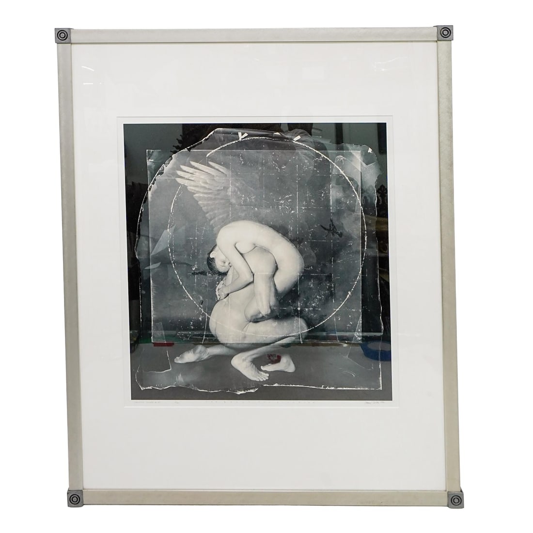 Vincent Serbin "Toward Omega Series" Silver Gelatin Print: DESCRIPTION: This is an artwork featuring a surreal composition. The image depicts a human figure in an intricate pose, appearing to be folded into itself. The figure has wings. A circular shape surro