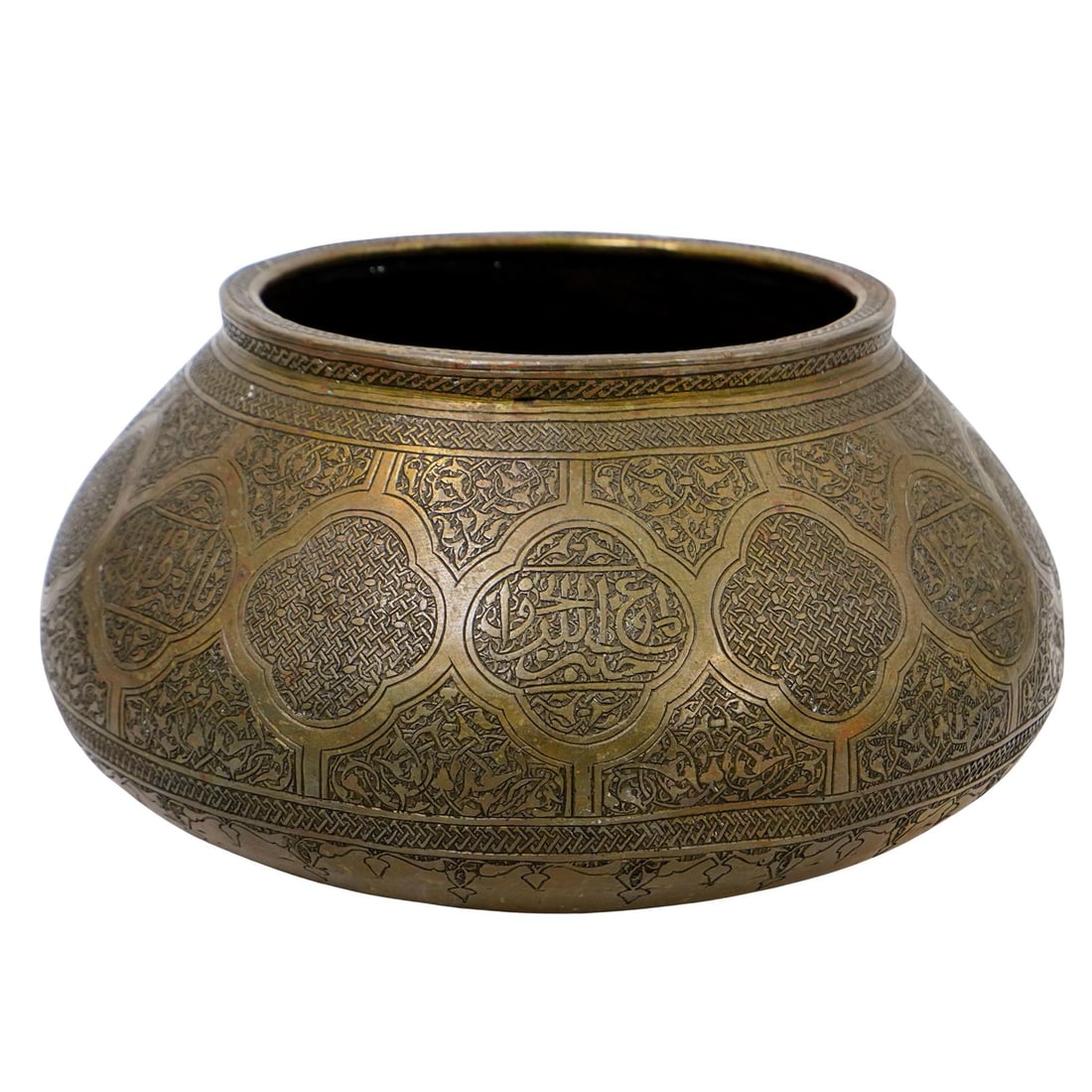 Antique Qajar Dynasty Persian Engraved Bronze Bowl: DESCRIPTION: Antique Qajar Dynasty Persian engraved bronze bowl, featuring repeating medallions filled with Arabic calligraphy. The surrounding areas are decorated with cross arched patterns and inter